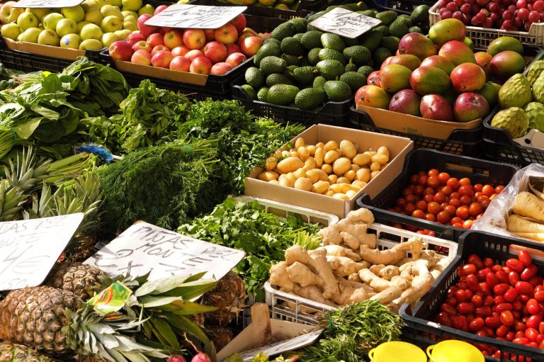 Bunte Auswahl an frischem Obst und Gemüse auf einem Marktstand.